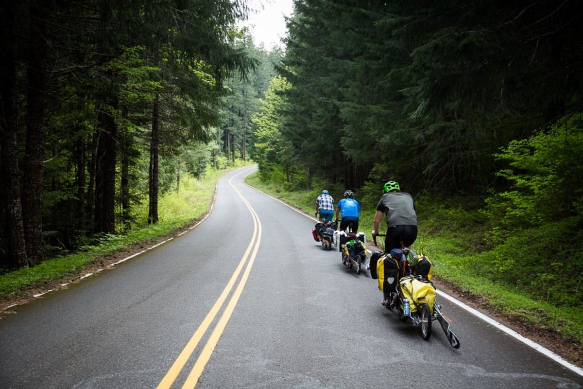 Ben Horan, Mike Wolfe, and Phil Grove pedal down an Oregon road, skis in tow. PHOTO: Tom Robertson