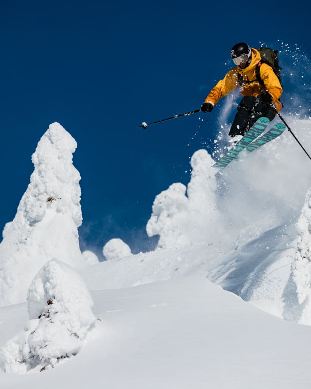 Skier flying through powder into mid-air at Revelstoke Mountain Resort